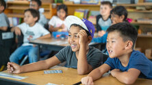 two boys sitting in class smiling 